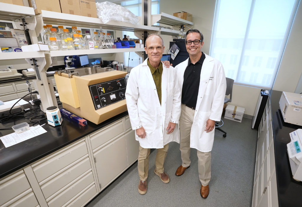 two men standing together in a lab