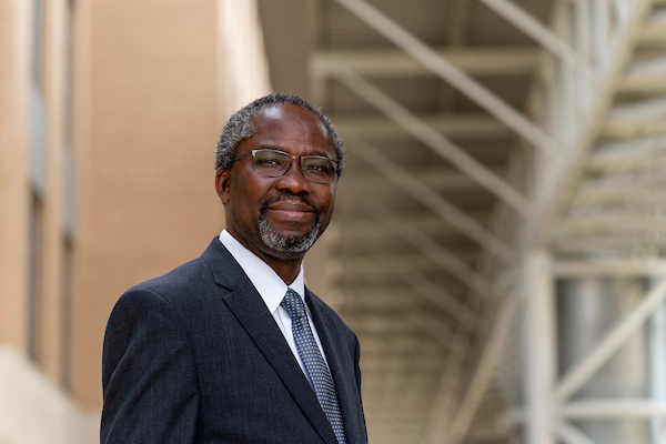 Henry Fadamiro headshot standing outside of the AGLS building. 