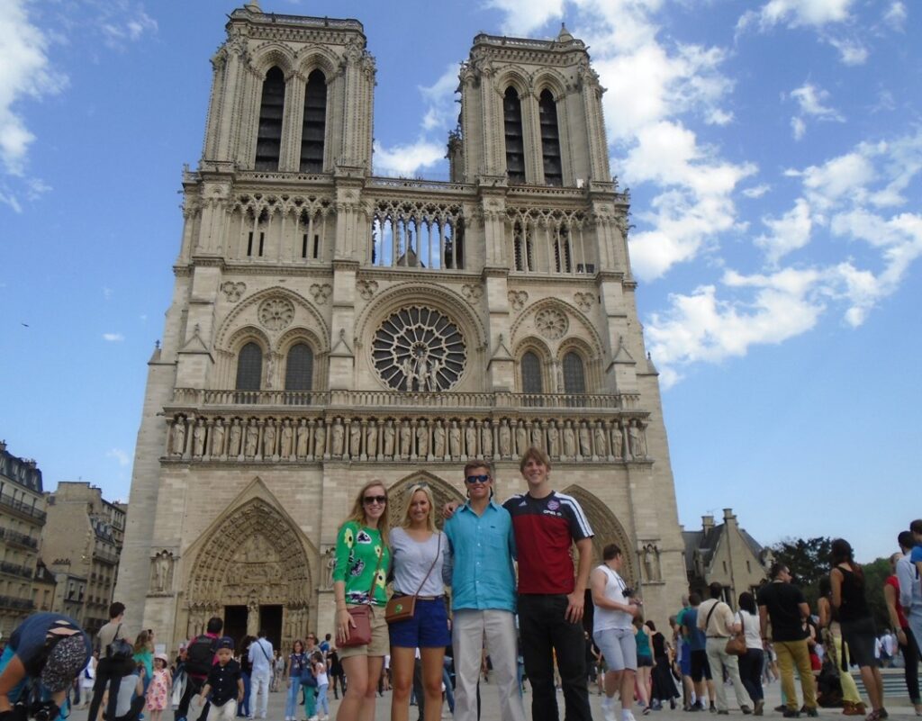 Group of four people standing infant of a historical building in Toulouse, France.